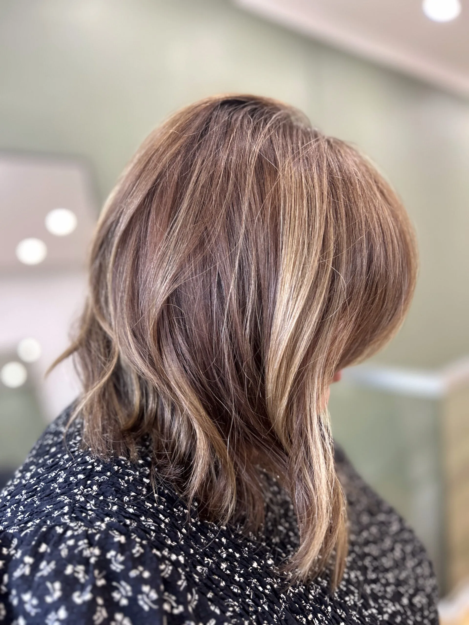 Shoulder-length caramel bob with blonde highlight ribbons
