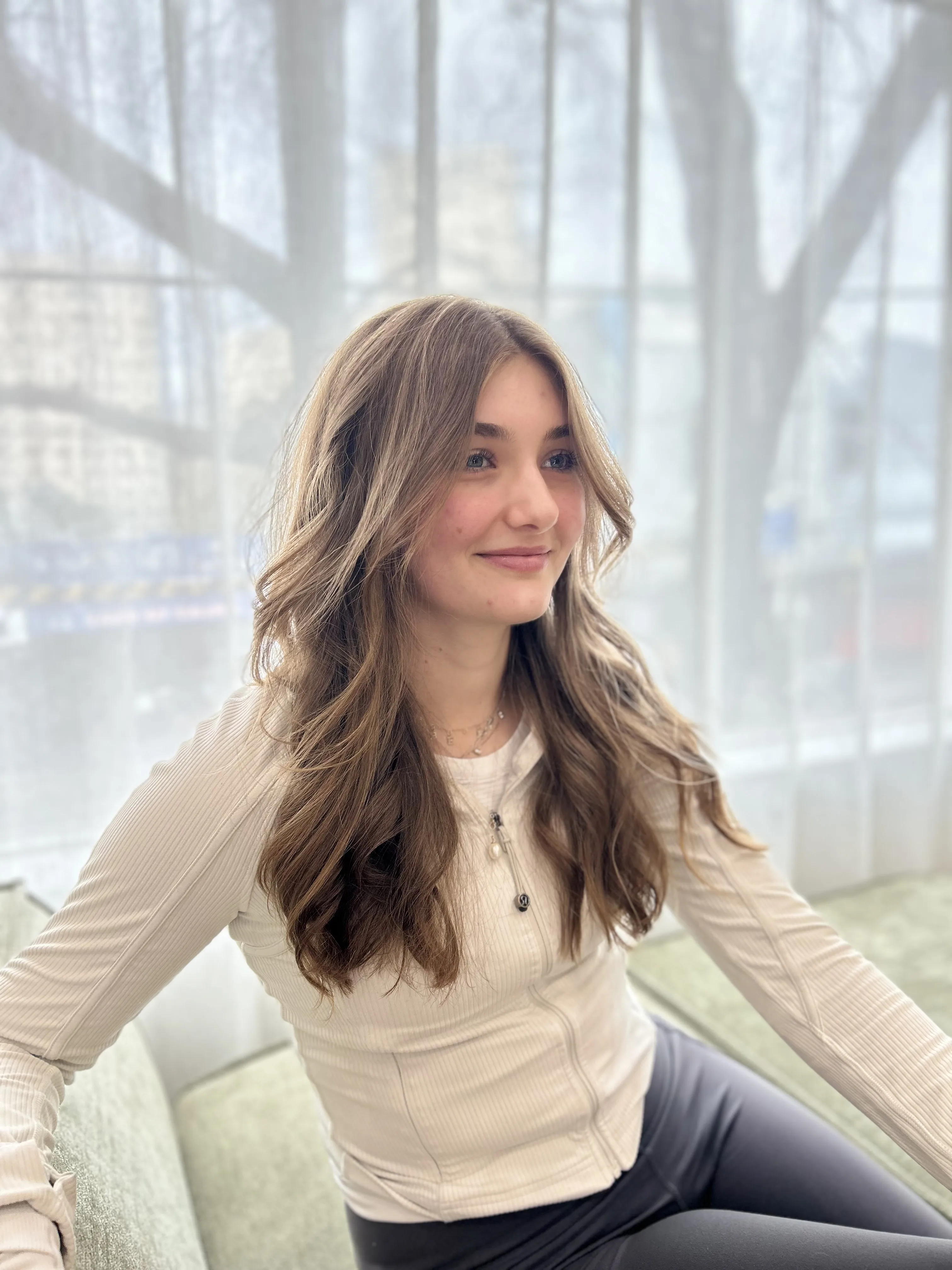 Seated client smiling, long light-brunette waves