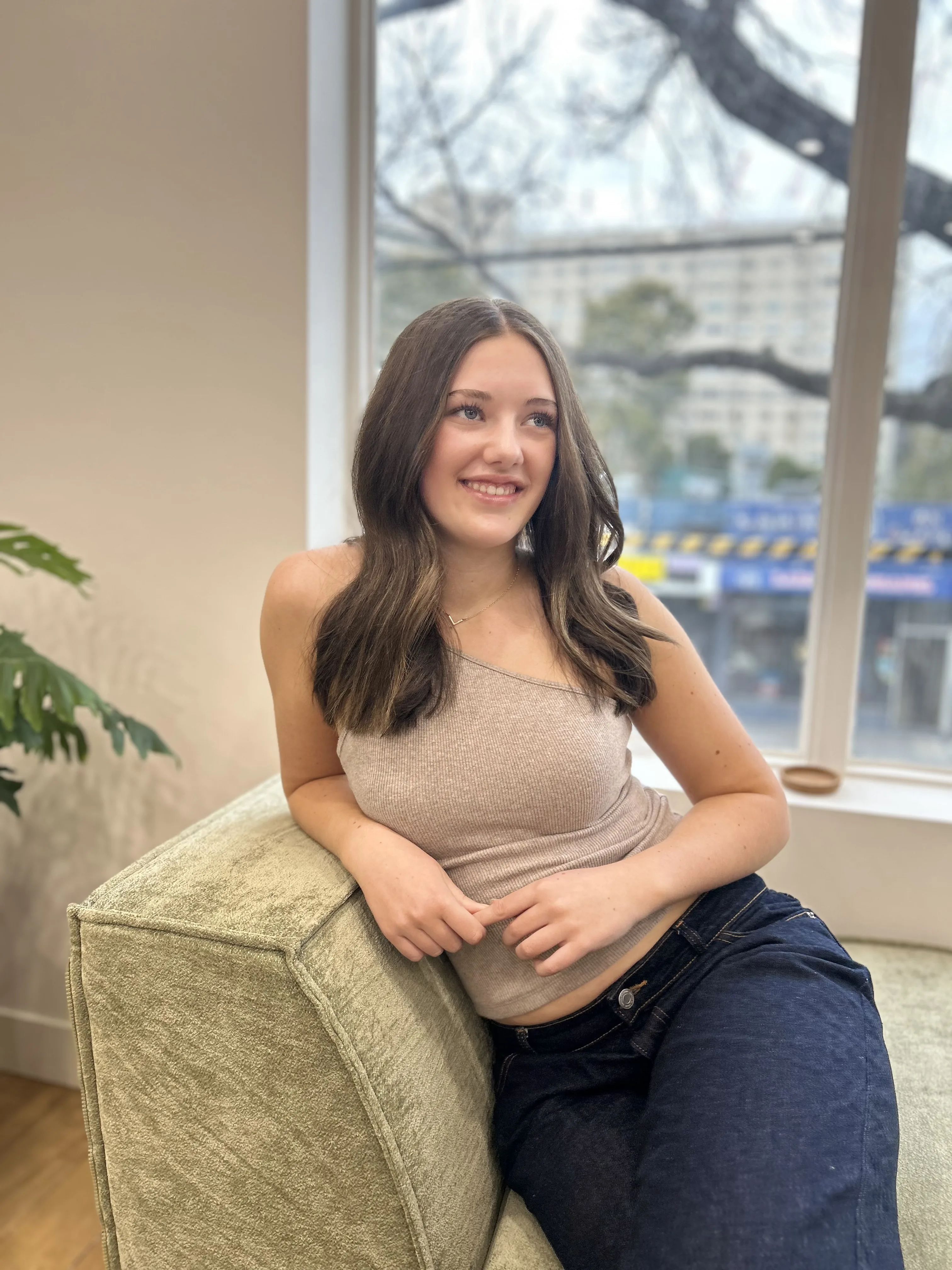 Seated client smiling, long dark-brunette waves