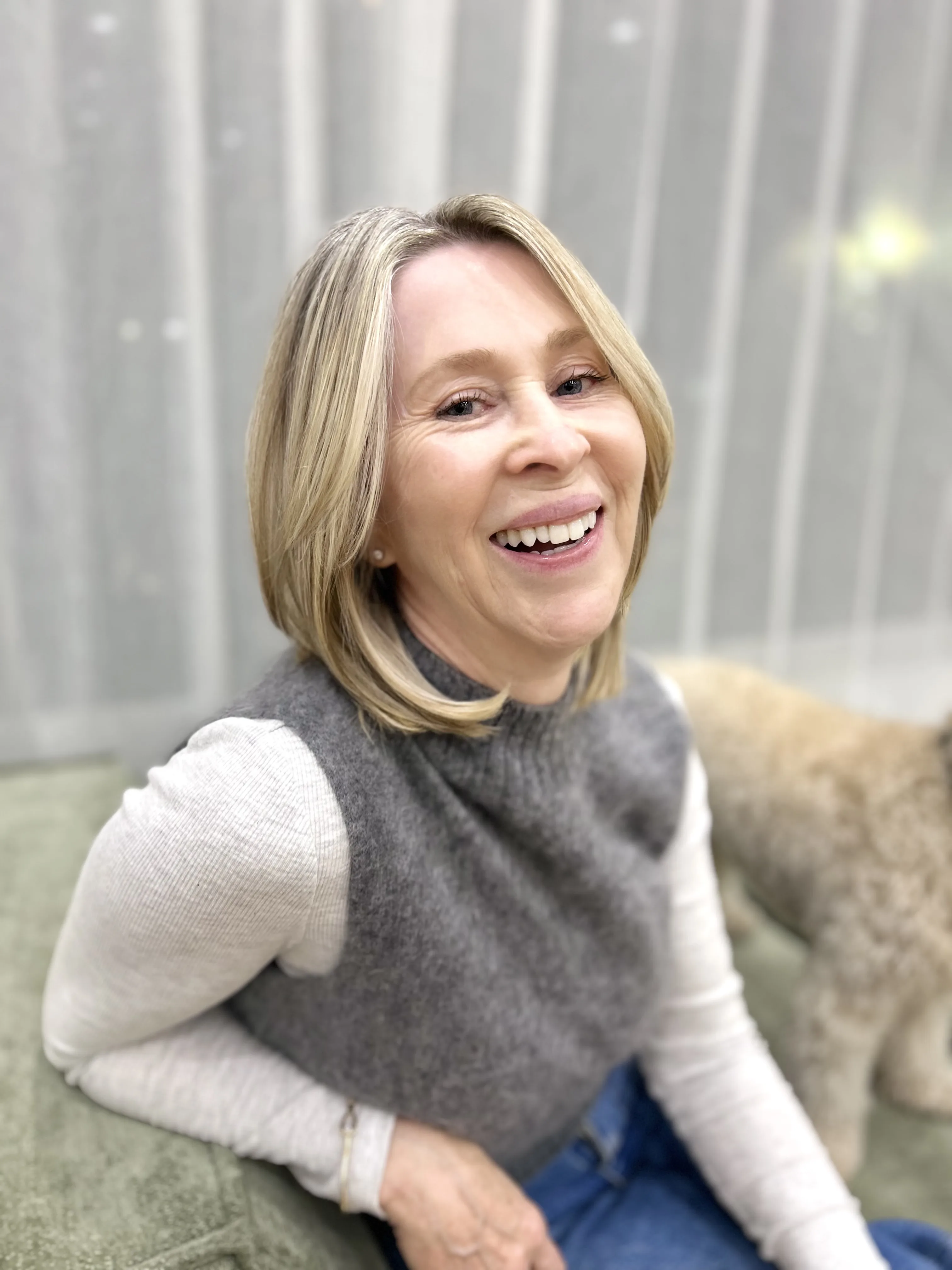 Client laughing warmly, blonde chin-length bob